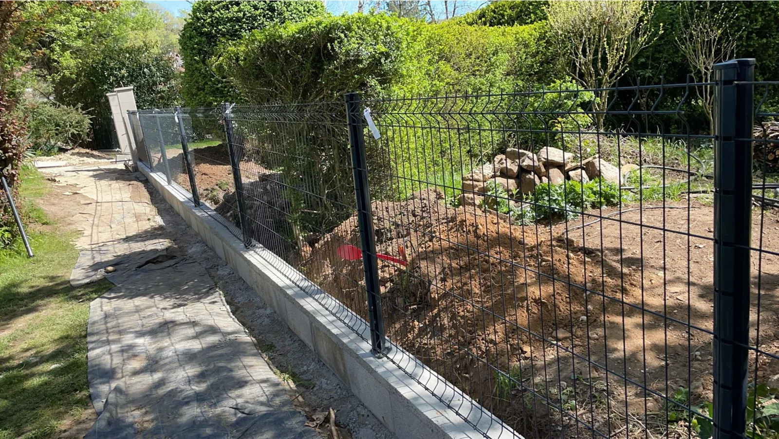 Clôture en grillage rigide posée sur un soubassement maçonné