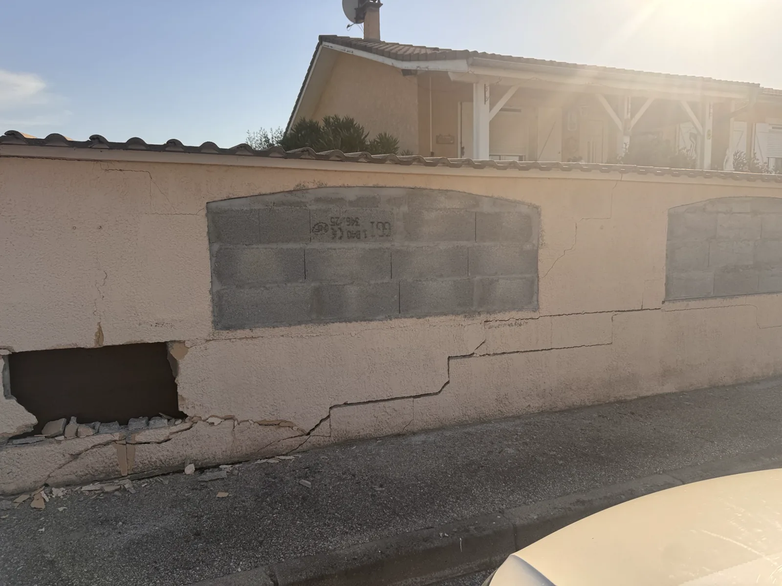 Mur de clôture fissuré avant démolition