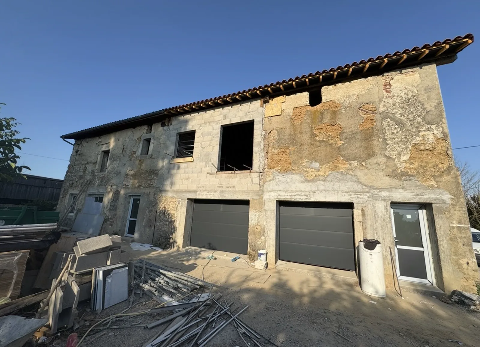 Bâtiment ancien en pisé après création de deux ouvertures de garage