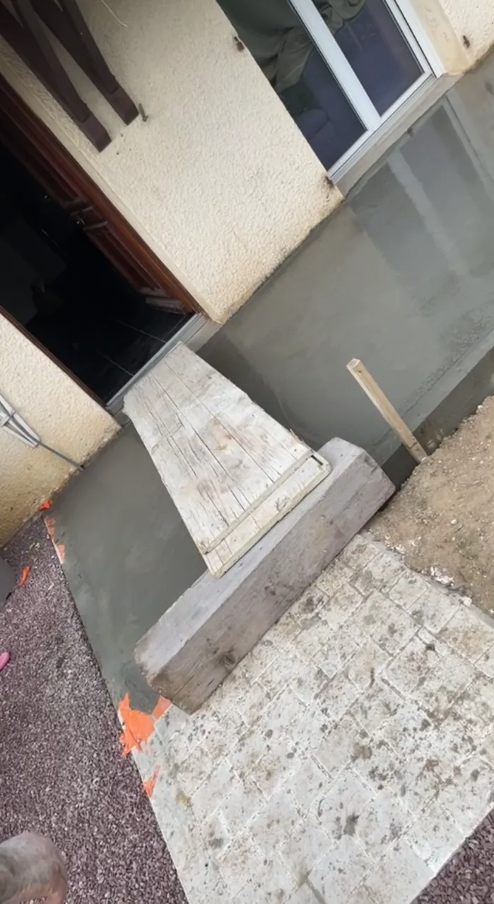 Terrasse en béton fraîchement réalisée devant une maison